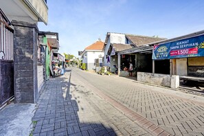 En smal gade kantet af bygninger, hvor nogle har butikker i stueetagen.
