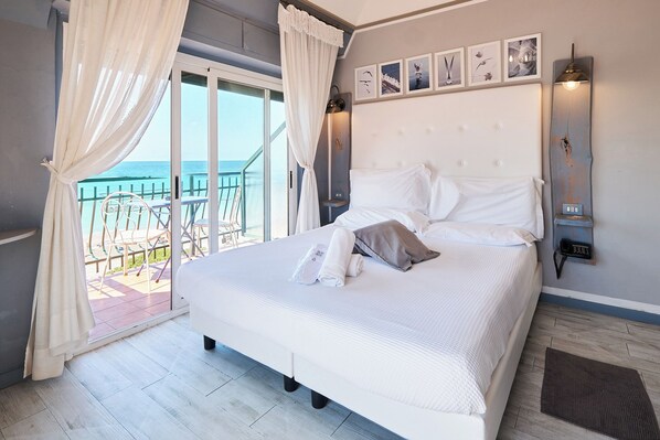 Habitación Deluxe, vista al mar | Edredón, camas con efecto memoria y caja de seguridad en la habitación 