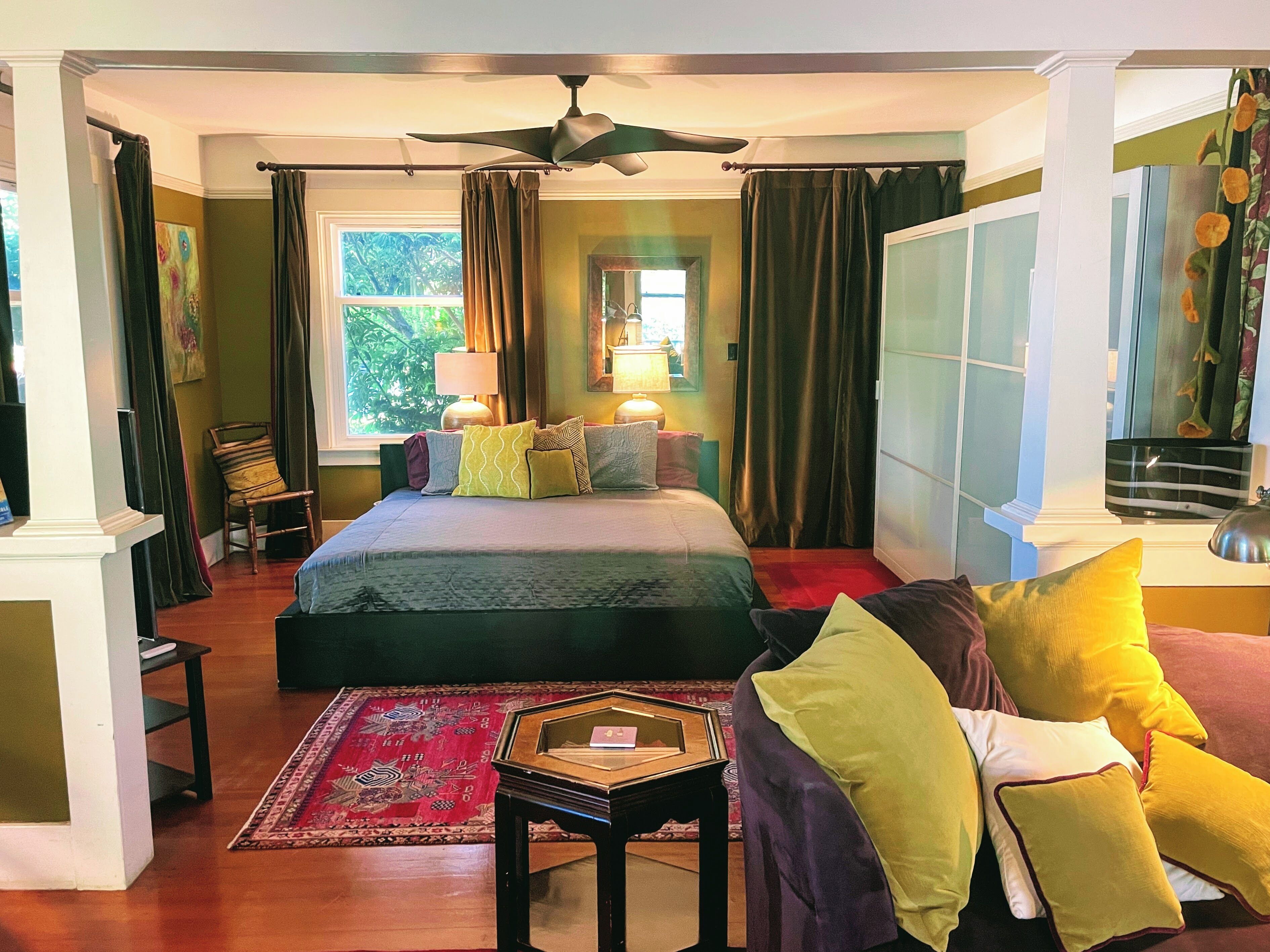 A bedroom with a bed, a chair, a table, and a window.
