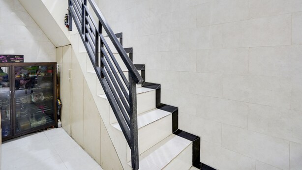 A staircase with black railings and white steps, leading to a lower level. - OYO Life 91893 Kost Jeje Syariah (Surabaya)
