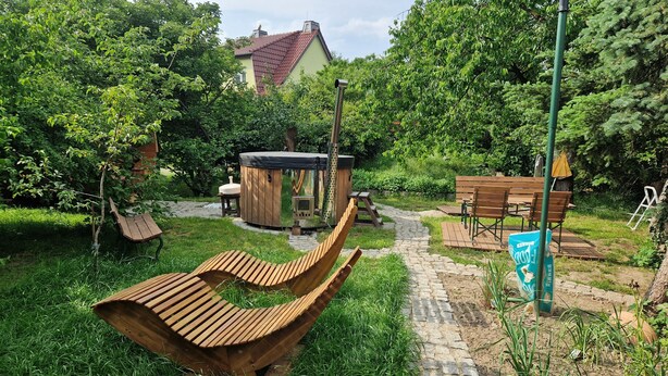 A garden with a wooden bench, a hot tub, and a wooden deck. - Auszeit in Ruhiger Lage (Schönfeld)