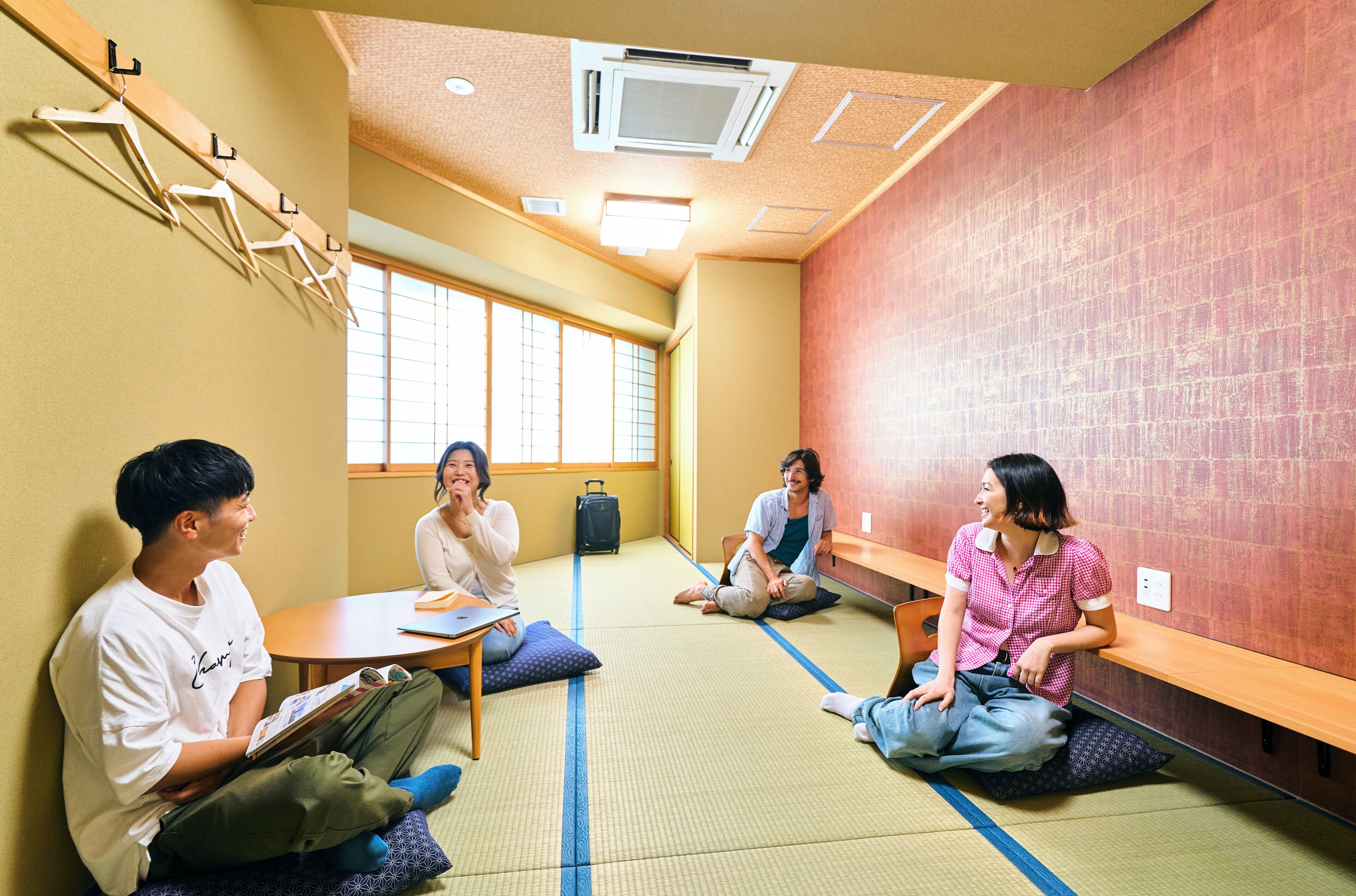 Una stanza con tatami, un banco di legno, un tavolo e una finestra vista panoramica.