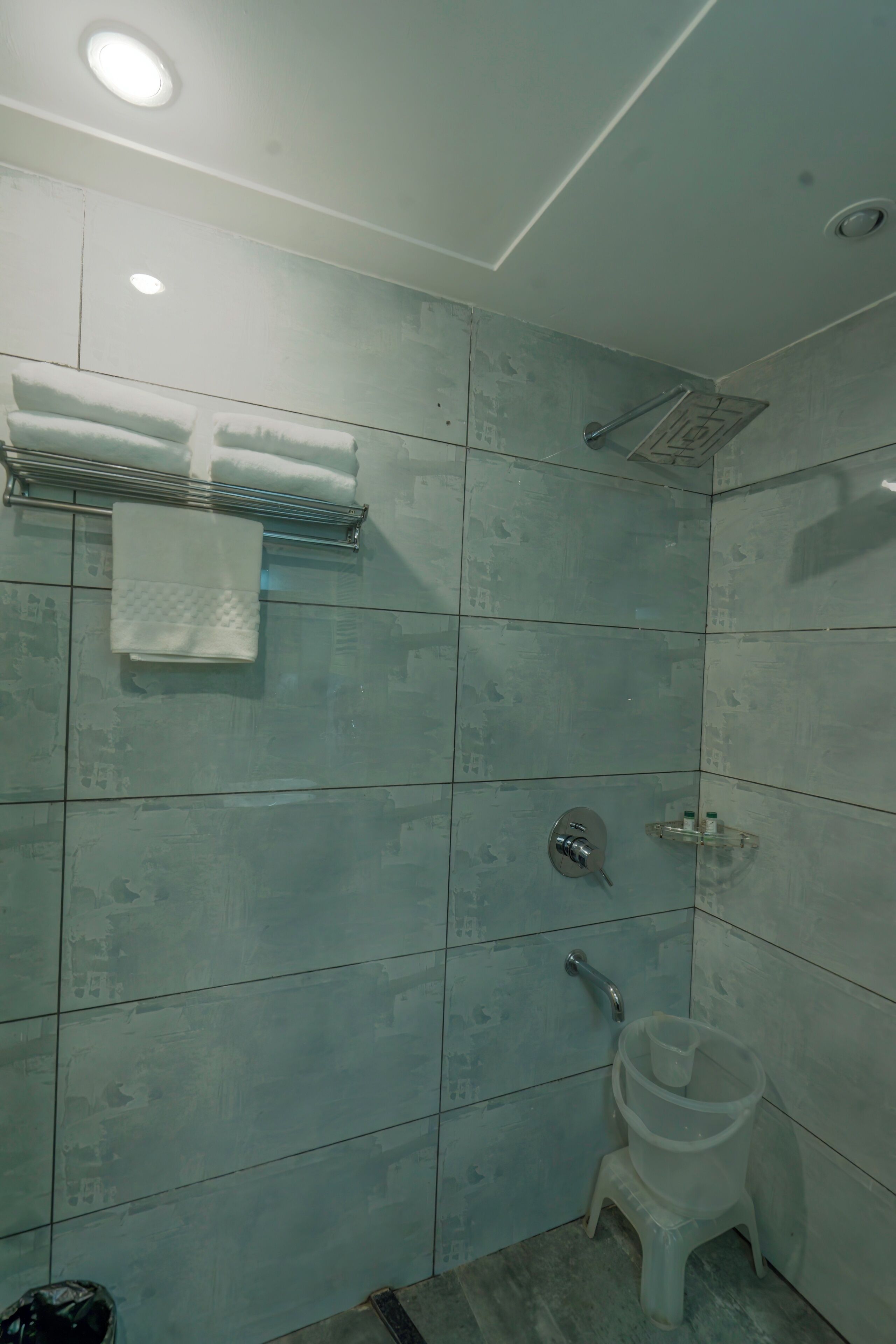 Un baño con ducha, inodoro y toallero.