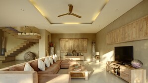 A spacious living room with a modern design, featuring a large sofa, a coffee table, a TV, and a wooden entertainment unit. - Villa Seminyak 3 Bedroom (Seminyak)