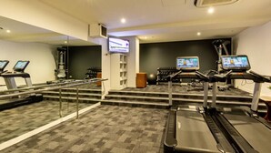 A gym with treadmills, stationary bikes, and a mirrored wall. - Elegance and heritage stay - CBD (Melbourne)
