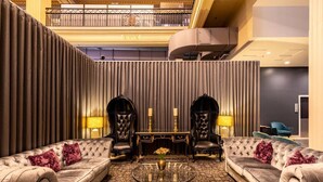 A luxurious lobby with a high ceiling, a central round table, and two sofas with armchairs. - Elegance and heritage stay - CBD (Melbourne)