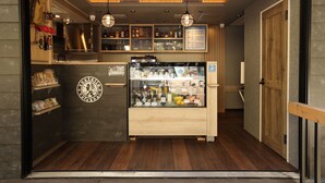 Eine gemütliche Bar mit Holzböden, einer Glasvitrine und einer Holztür.