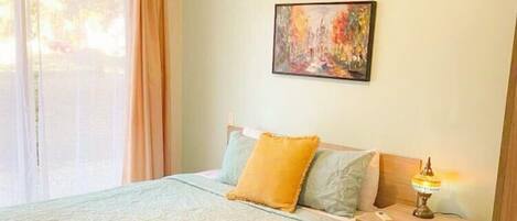 Un dormitorio con cama, mesita de noche y ventilador de techo.