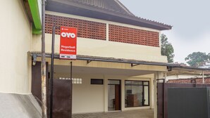 Un immeuble de deux étages sur lequel est apposée une enseigne publicitaire pour l’hôtel OYO Hegarthy Residence.