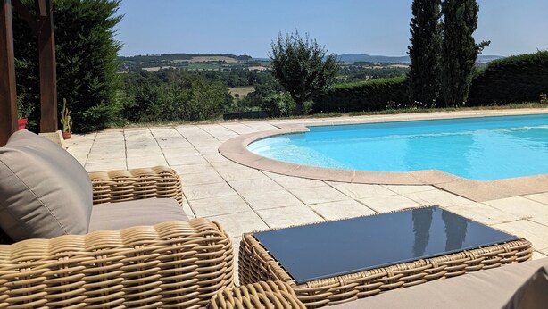 A poolside area with wicker furniture and a view of the countryside. - Large House with Private Pool and Valley View (Savigny-sur-Grosne)