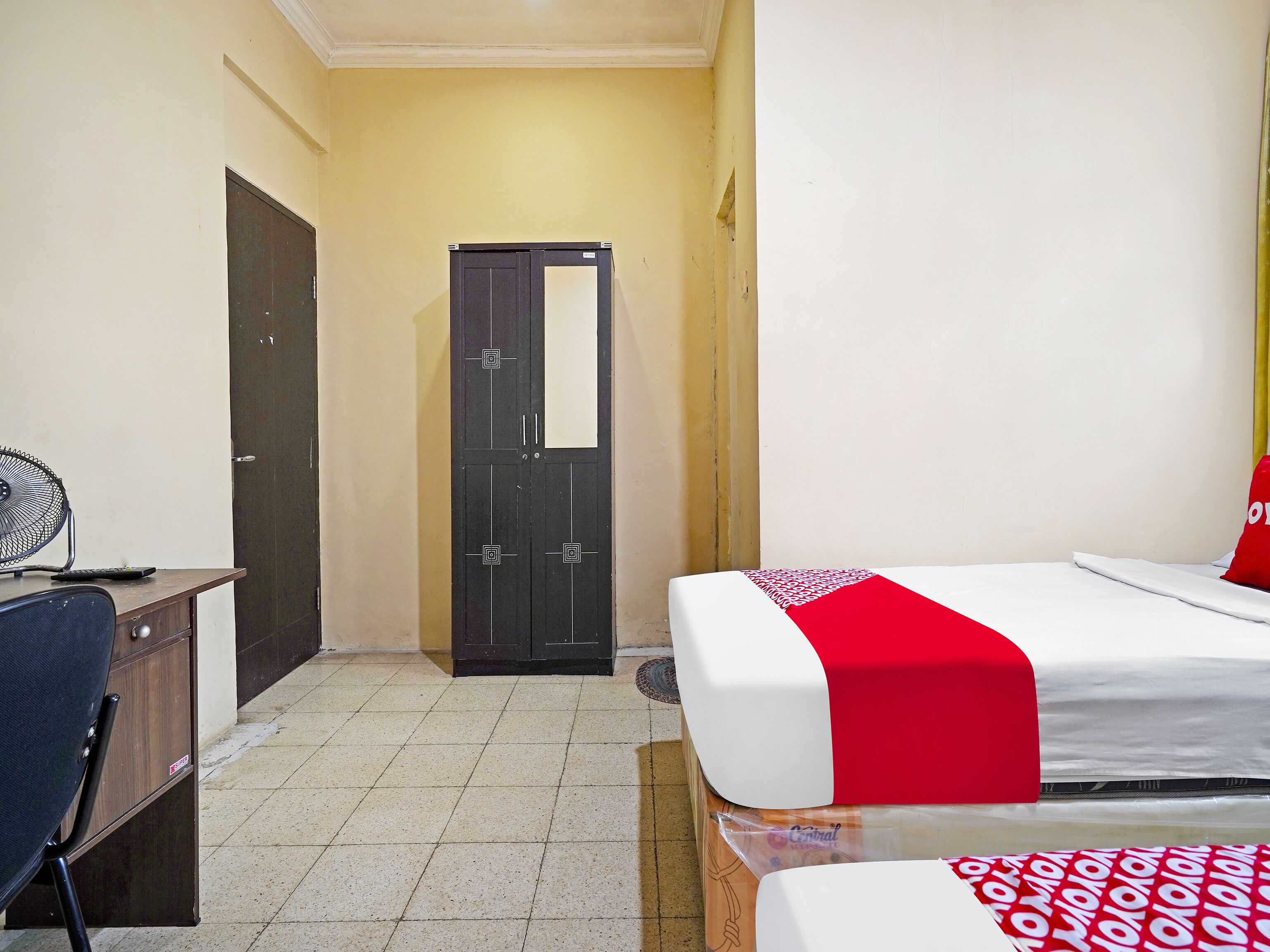 Une chambre d’hôtel comprenant un lit, un bureau, une chaise et une armoire.