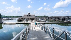 A marina with a central building, docked boats, and a pedestrian bridge. - Beautiful Lake Home Retreat with Lake and Marina Access and Golf Cart (Winchester)