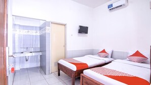 Een hotelkamer met twee bedden, een badkamer en een televisie.