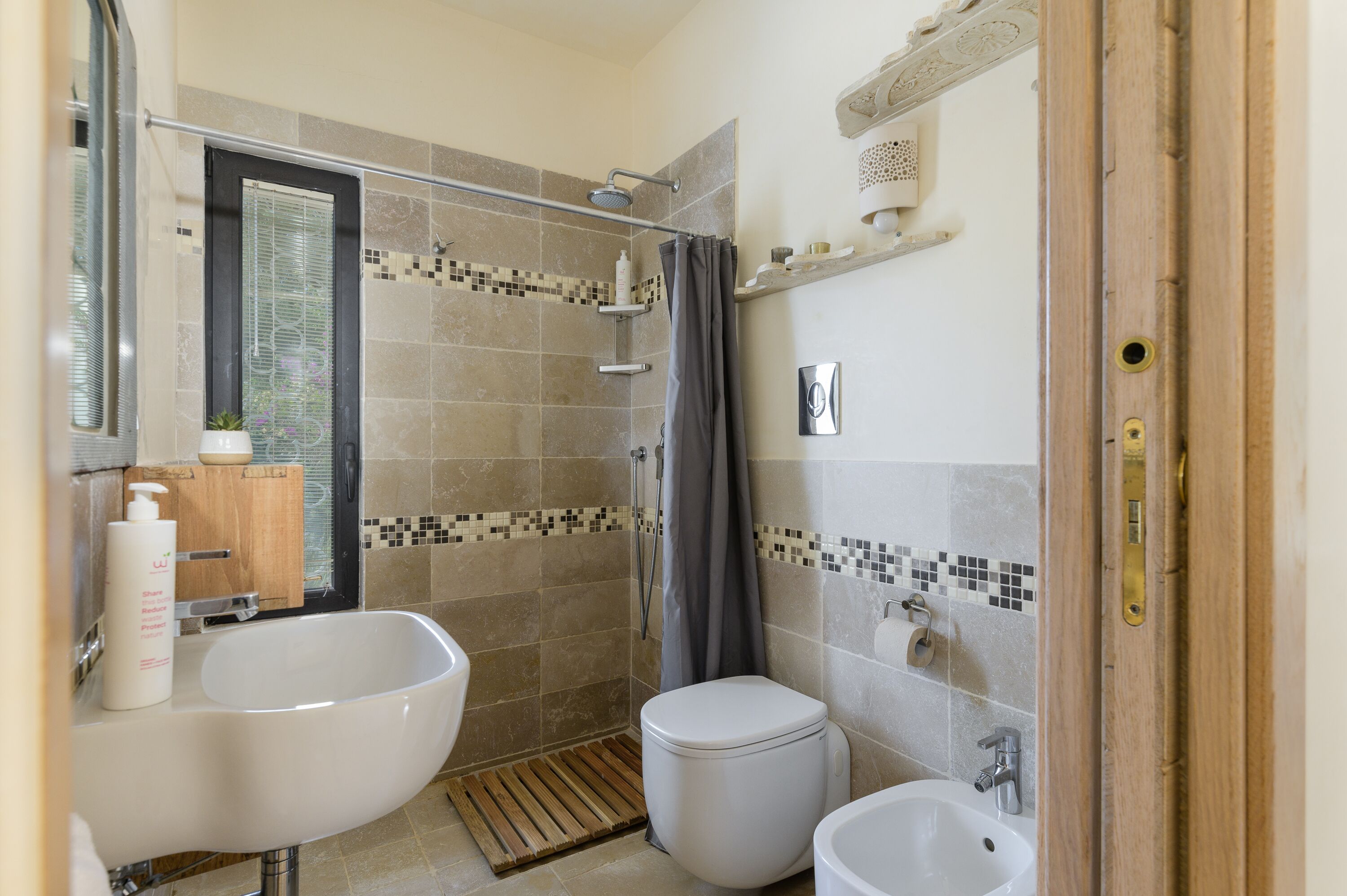 A bathroom with a bathtub, toilet, and sink.