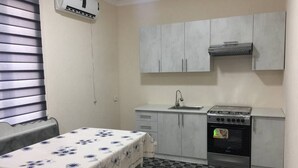 A compact kitchen with a stove, sink, and cabinets.