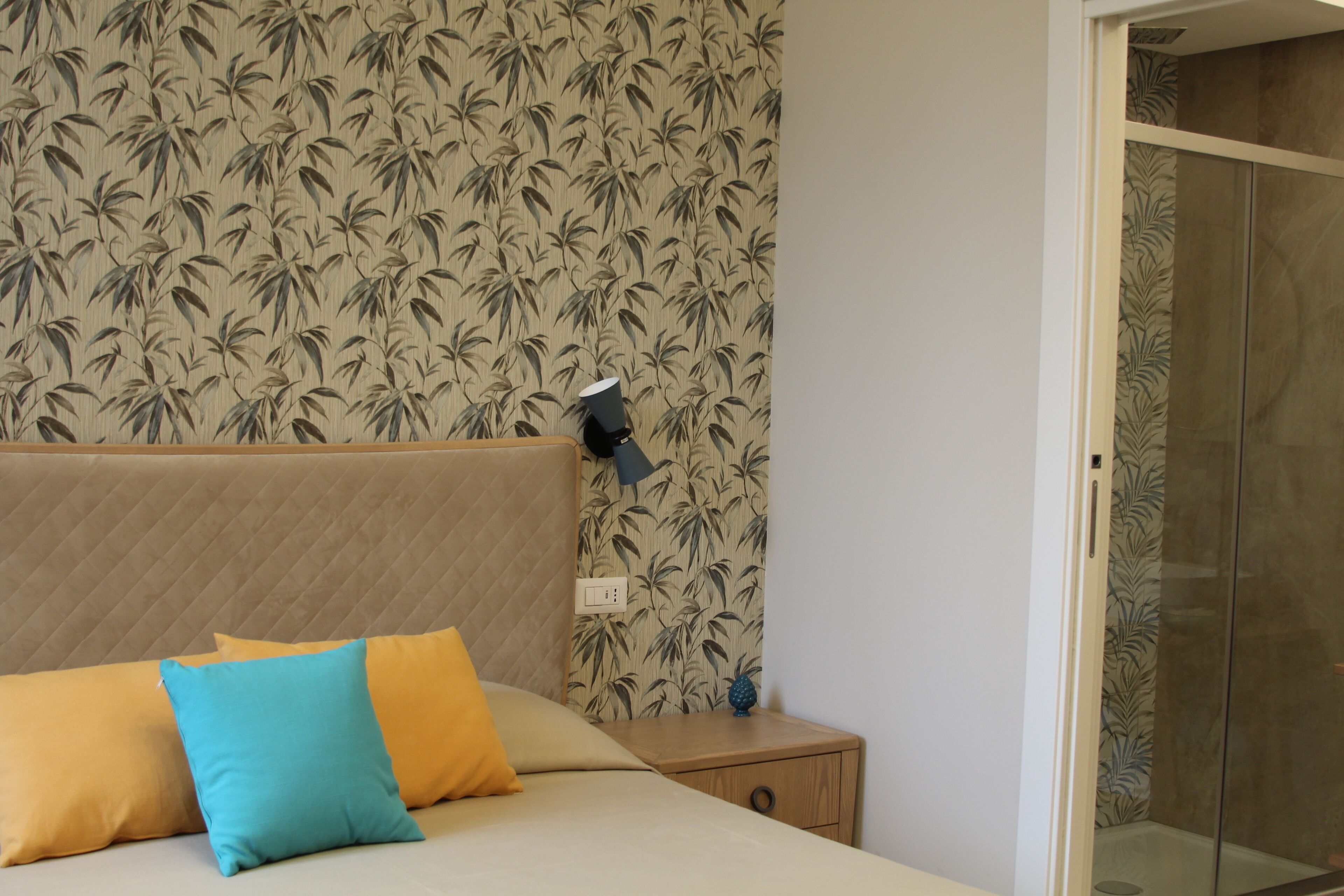Une chambre à coucher avec un lit, deux oreillers, une table de chevet, une lampe et une armoire.