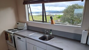 Uma cozinha com fogão, pia e janela com vista para uma paisagem deslumbrante.