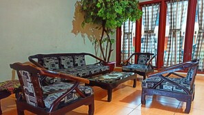 Une pièce comprenant un canapé, deux fauteuils et une table basse, tous recouverts d’un tissu à motifs.