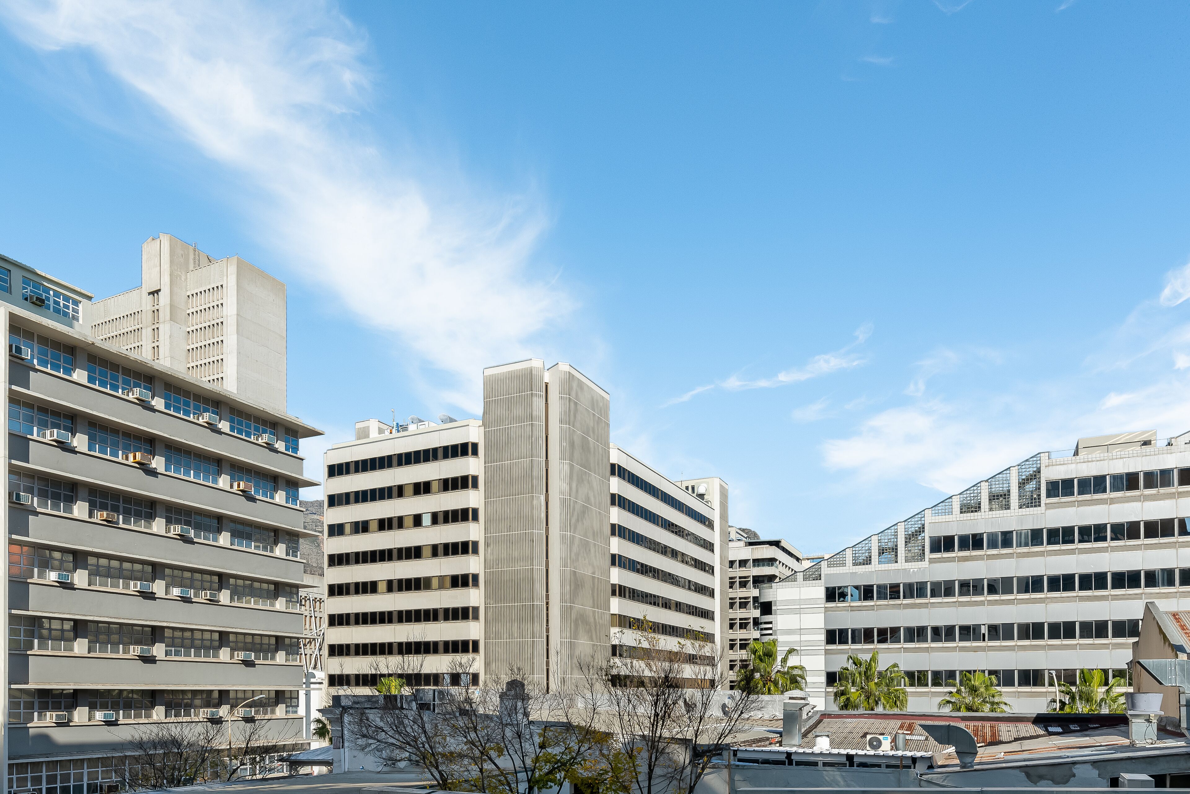 A modern building with multiple floors, large windows, and a flat roof.