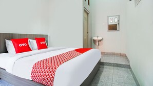 A hotel room with a bed, a bedside table, a wall-mounted TV, and a small window. - Hotel O Teluk Betung Near Taman Dipangga Formerly Z Hotel (Bandar Lampung)