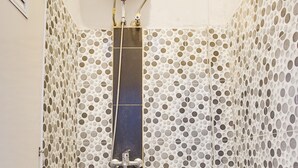 A bathroom with a toilet, shower, and tiled walls with a polka dot pattern. - Hotel O Teluk Betung Near Taman Dipangga Formerly Z Hotel (Bandar Lampung)