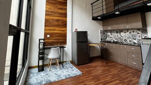 Eine moderne Küche mit eingebautem Herd, ein Essbereich mit Tisch und Stühlen sowie ein großes Fenster für natürliches Licht.