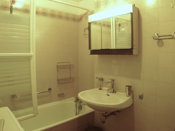 A bathroom with a bathtub, a sink, and a mirror. - Comfortable & bright 2-room in Samoëns center - Pets allowed and parking included (Samoëns)