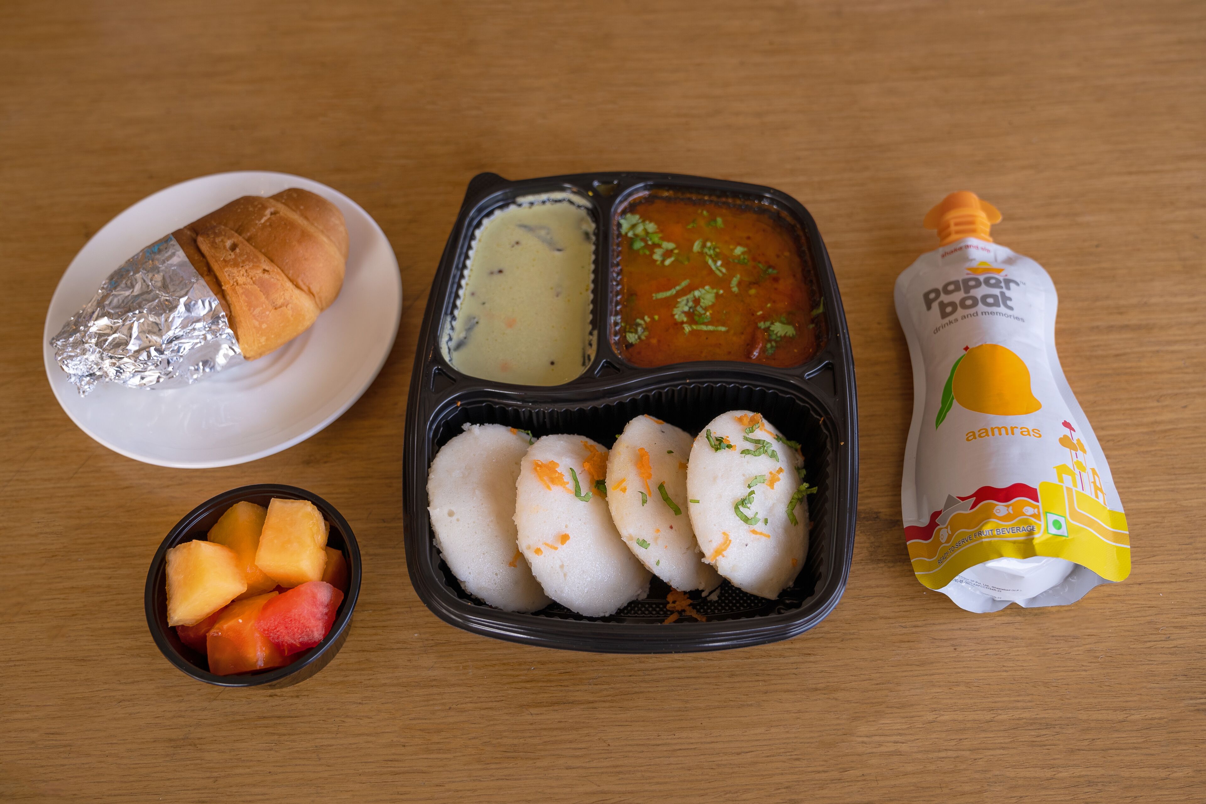 A meal with bread, soup, and a drink.