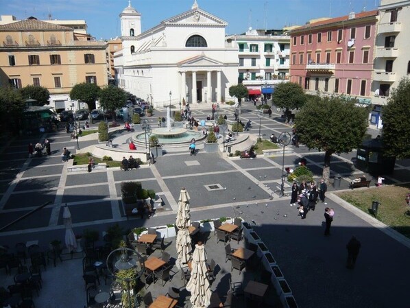 A public square with a central fountain, surrounded by cafes and outdoor seating. - Central apartment in Anzio (Anzio)