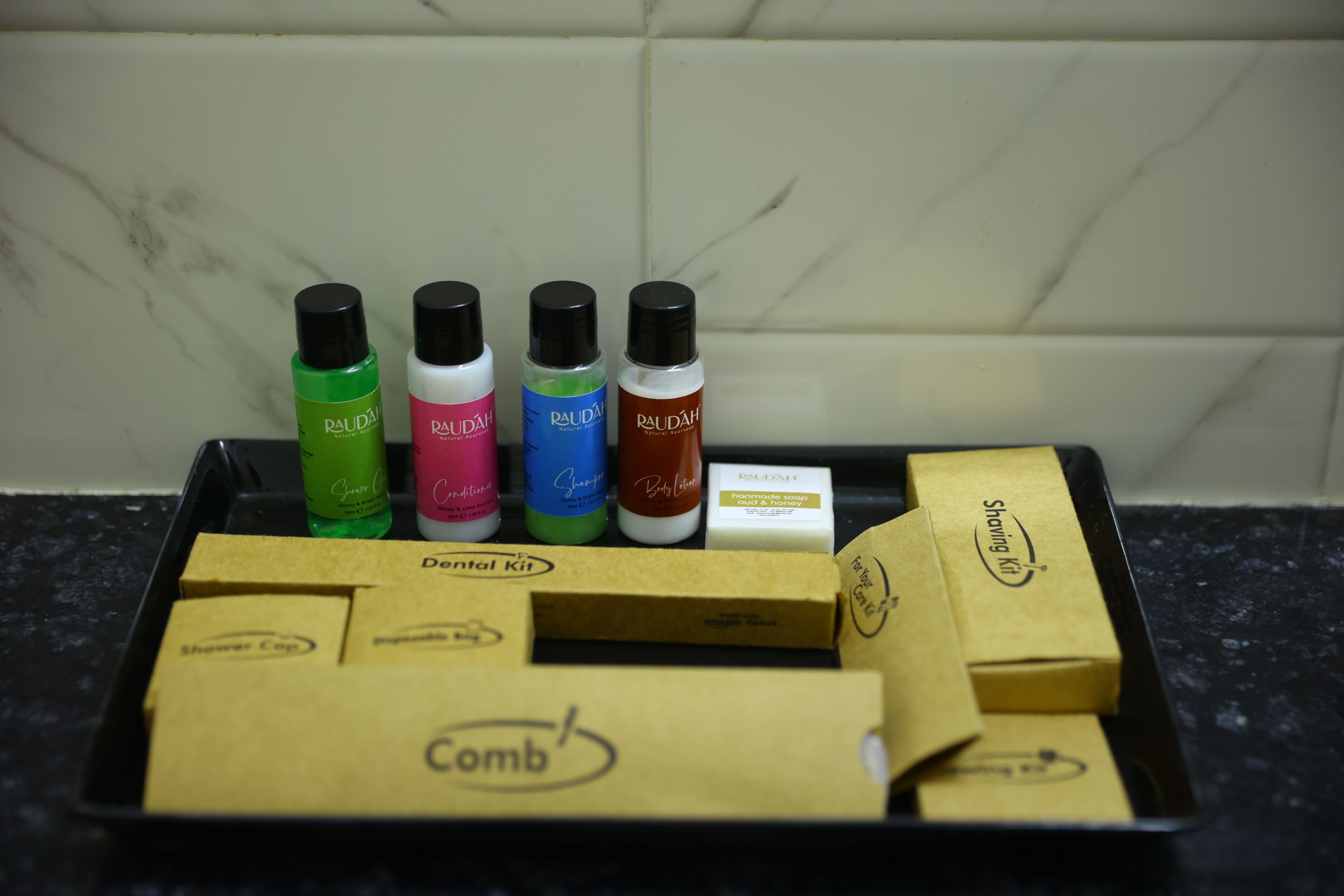 A tray with various personal care items and boxes, likely for a hotel stay.
