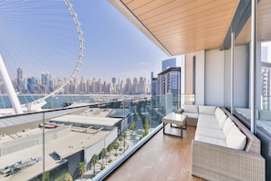 Ein moderner Hotelbalkon mit Blick auf eine Stadtlandschaft und ein Riesenrad.