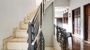 Una escalera con barandilla de metal que conduce a una plataforma con un banco.