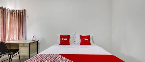 A hotel room with a bed, a desk, and a chair.