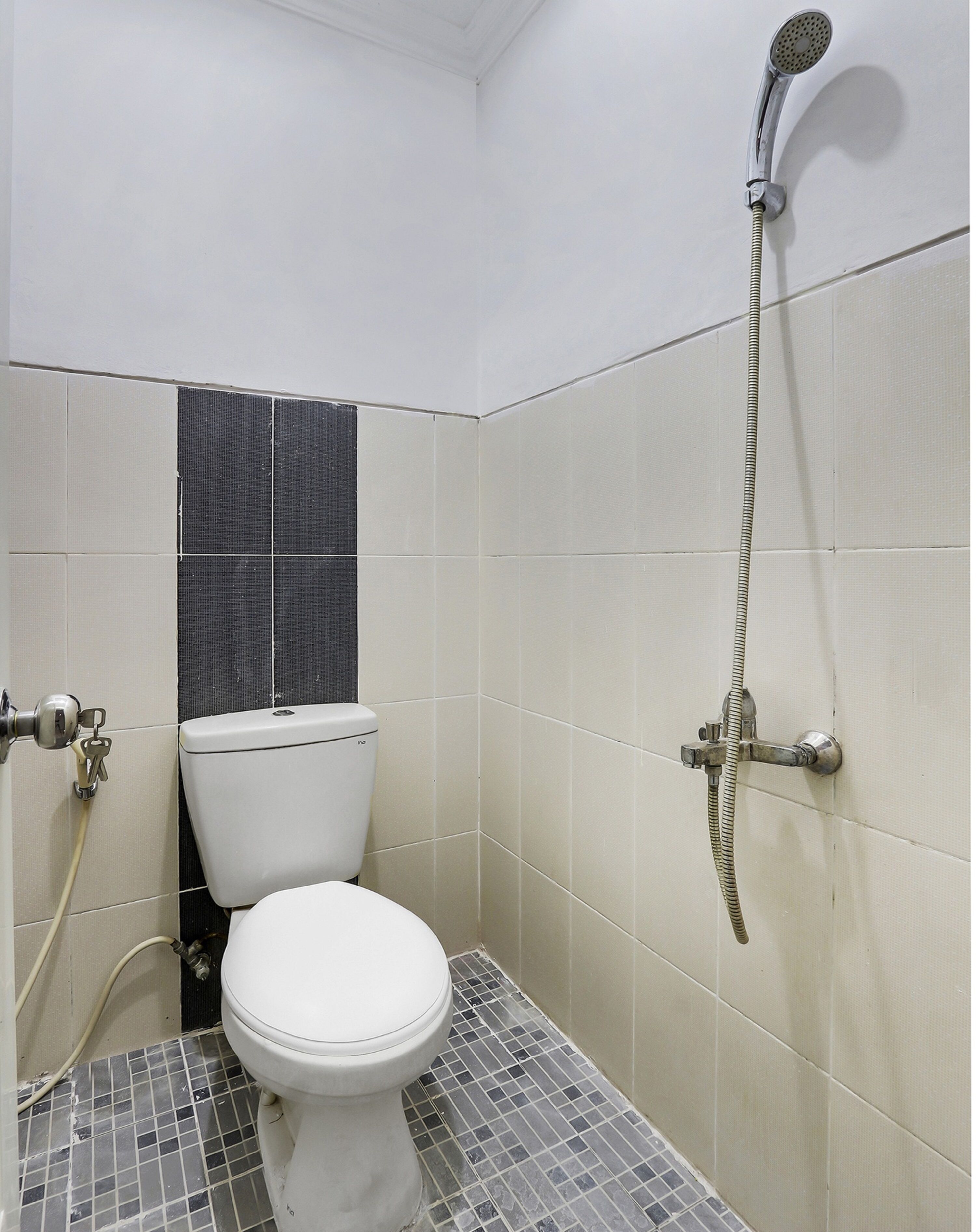 Un baño pequeño con inodoro, ducha y paredes de azulejos.