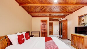 Une chambre à coucher avec un lit en bois, une télévision et une armoire.