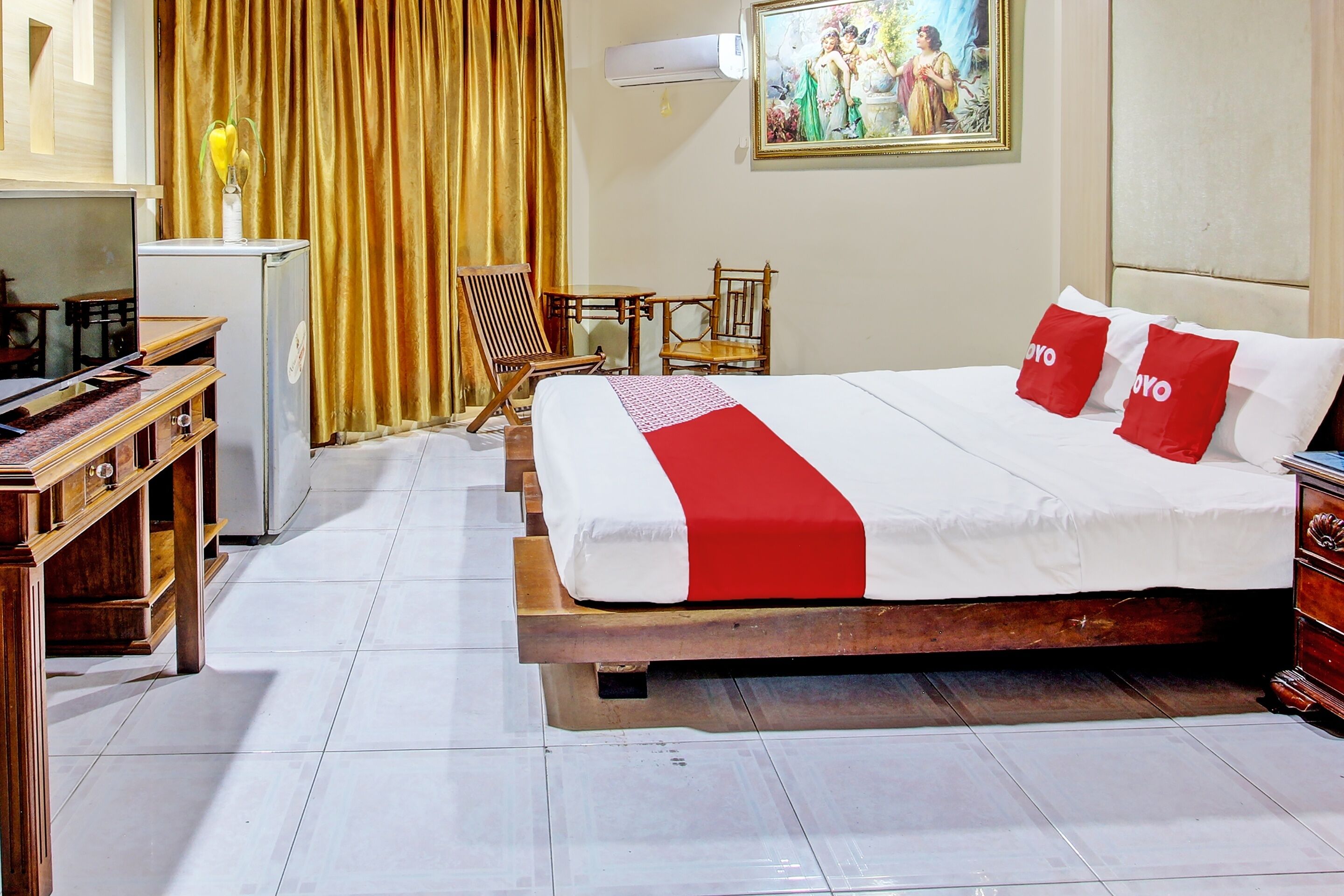 A hotel room with a bed, a desk, a chair, and a small table.