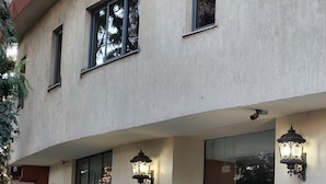 A building with a curved facade, multiple windows, and outdoor lighting fixtures. - Kora Hotel Suites (Addis Ababa)