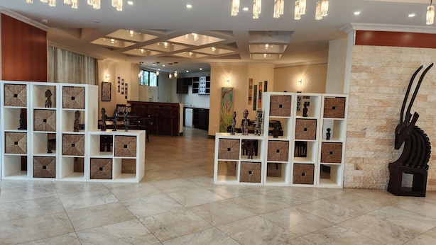A spacious lobby with modern lighting, a central seating area, and decorative shelves with items. - Kora Hotel Suites (Addis Ababa)