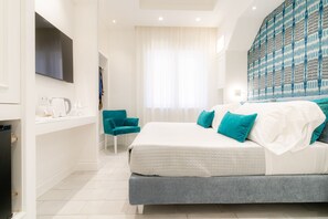 A modern bedroom with a large bed, a flat-screen TV, a bathroom with a sink and mirror, and a patterned wall.