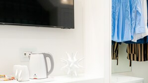 A modern bathroom with a white countertop, a kettle, and a flat-screen TV mounted above. - L'INCANTO DI CIOFFI ROOMS (Sorrento)
