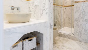 A bathroom with a marble sink, a glass-enclosed shower, and a mirror above the sink. - L'INCANTO DI CIOFFI ROOMS (Sorrento)