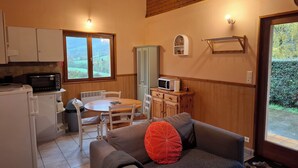 A cozy living area with a sofa, a dining table, and a kitchen area with a microwave and toaster.