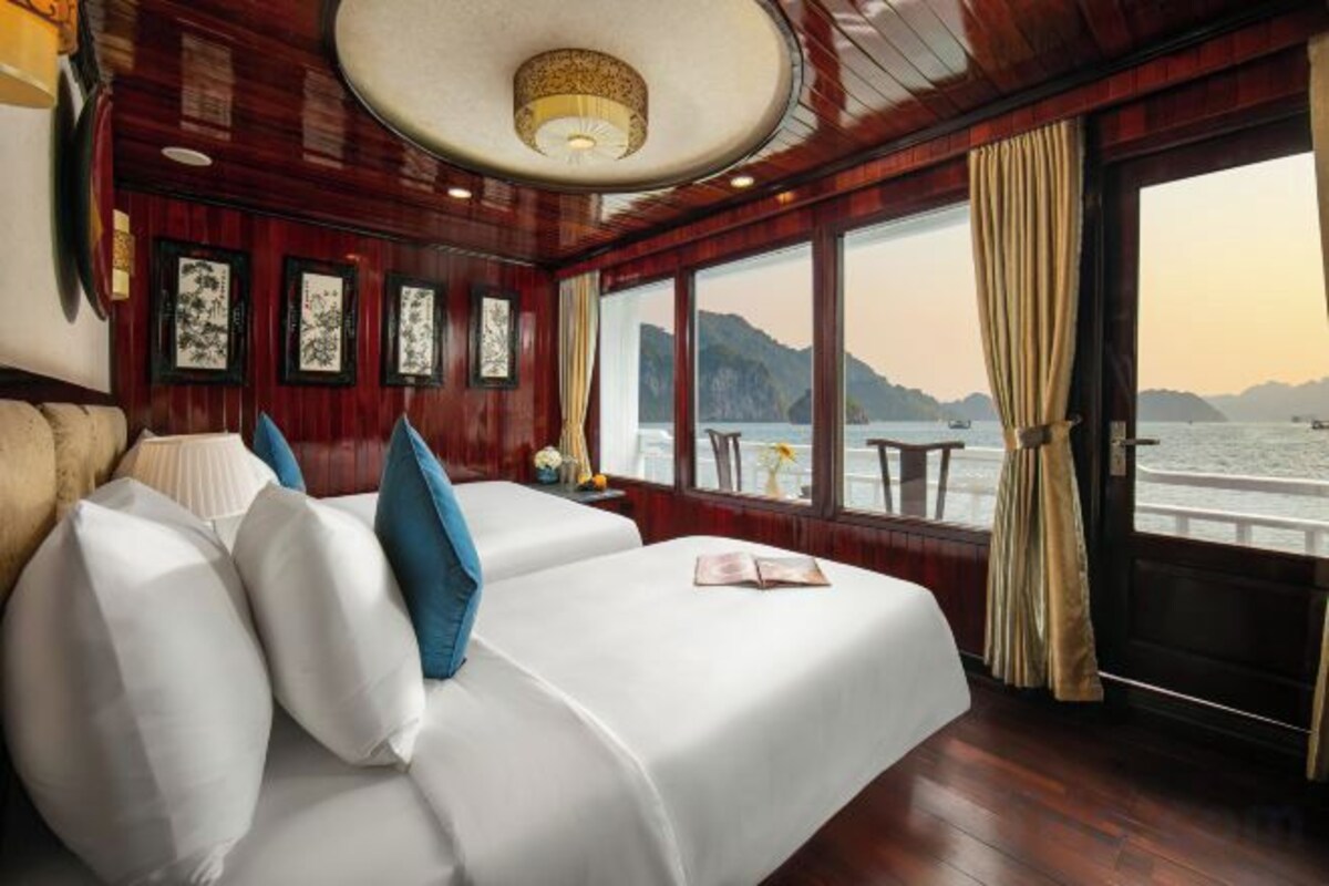 Una habitación con cama, ventana con vista al mar y puerta que da al exterior.