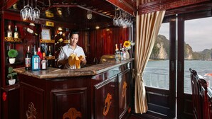 A bar area with a view of the sea, wooden paneling, and various bottles and glasses. - La Regina Classic Cruise (Bai Chay)
