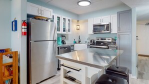 A modern kitchen with white cabinets, stainless steel appliances, and a central island. - 2nd floor, Boardwalk to the Beach, Shared Pool (Port Aransas)