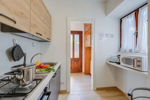 A kitchen with a stove, microwave, and wooden cabinets.