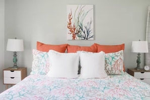 A bedroom with a bed, two nightstands, and a wall-mounted artwork.