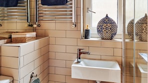 A bathroom with a white sink, a towel rack, a mirror, and a decorative vase. - Stylish Portobello Road 2 Bedroom Easy Access (London)