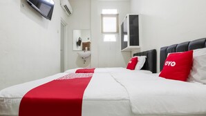 Een hotelkamer met een bed, een aan de muur bevestigde televisie, een raam en een spiegel.