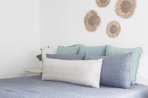 A bed with multiple pillows and a wall with decorative circular wall art. - Central Location l Steps from Ocean l Top Floor (Myrtle Beach)
